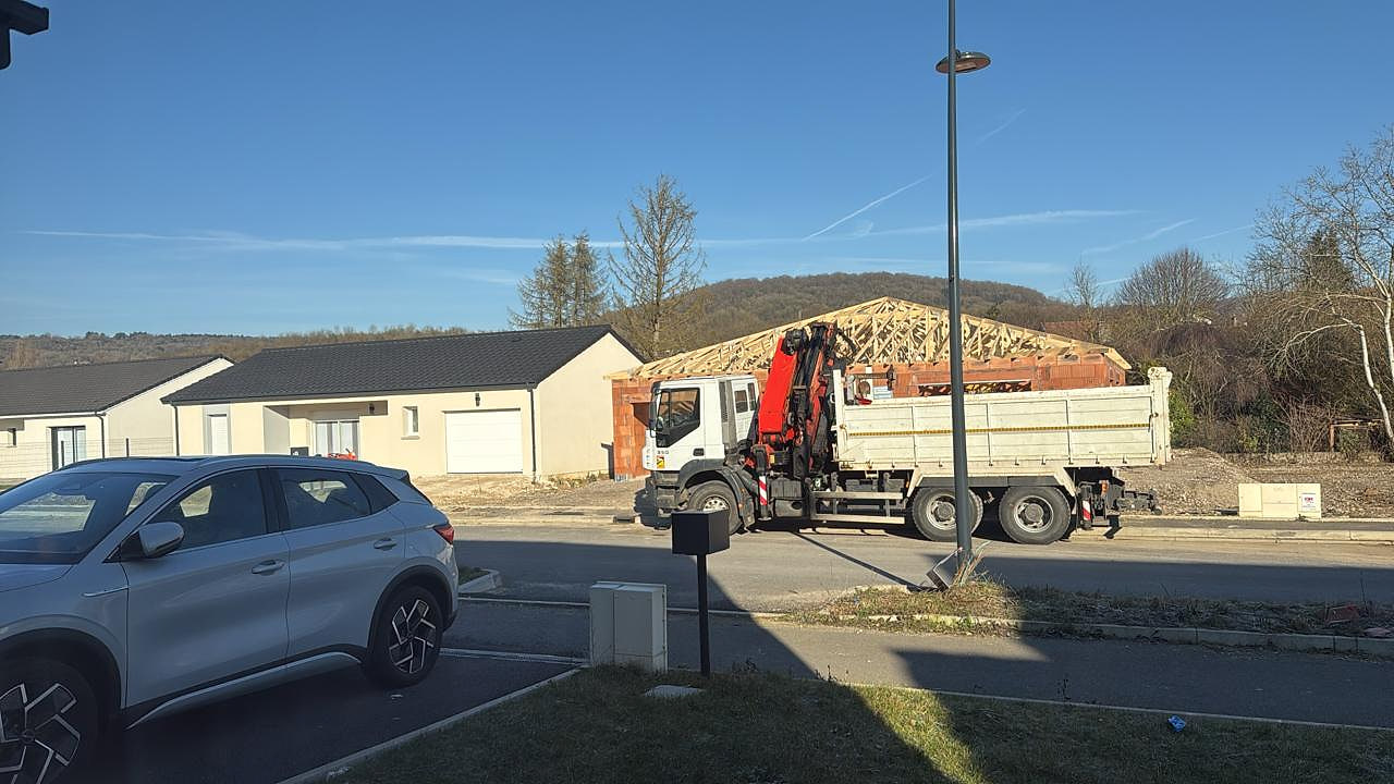 Camion-grue pour la livraison et le levage d'une charpente